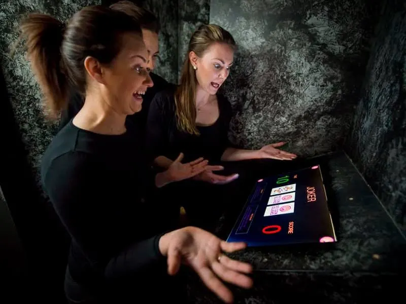 Trois joueuses découvrent leur score sur l'écran d'une cellule